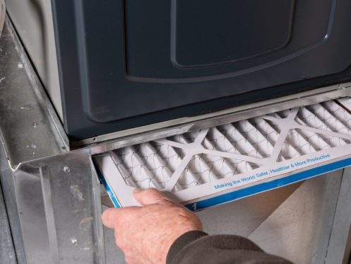 HVAC technician from Element Air replacing an air filter in a furnace, ensuring proper installation with the correct airflow direction for optimal heating efficiency. Contact us for expert help with which way should the arrow point on the air filter furnace, how to install an air filter in a furnace, correct direction for furnace air filter, which direction does air filter go furnace, furnace air filter installation guide, furnace filter orientation, air filter airflow direction furnace, air filter replacement furnace, HVAC filter direction, best way to install furnace filter, furnace filter installation near me, air filter furnace replacement near me, furnace repair near me, furnace maintenance services, furnace filter replacement, HVAC system repair near me, furnace services near me.
